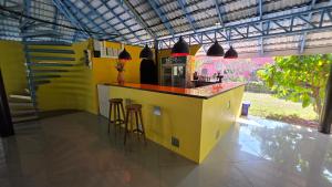 eine Küche mit einer gelben Theke und Hockern darauf in der Unterkunft OneSeasonFarm in Chiang Saen