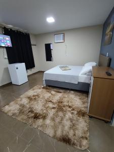 a bedroom with a bed and a rug at Chalé Montanhez com ar e piscina in Caparaó Velho +17 photos