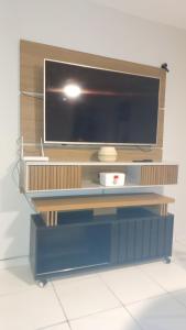 een flatscreen-tv op een houten entertainmentcentrum bij Sossego1 in Várzea Grande
