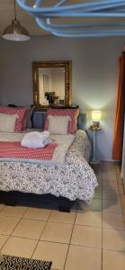 une chambre avec un grand lit avec un miroir dans l'établissement le chalet vert et bain nordique au feu de bois, à Frambouhans