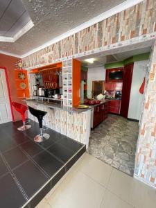 eine große Küche mit roten Schränken und einem roten Hocker in der Unterkunft Ngami Gates Boutiqúe Guesthouse in Maun