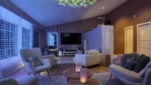 een woonkamer met banken en een televisie bij Arctic Luxe Retreat in Rovaniemi