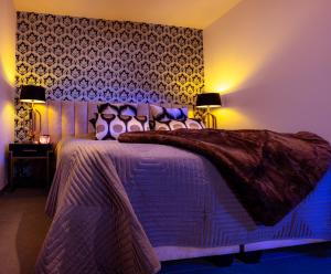 a bedroom with a bed with a purple comforter at SuiteDreams - Ruby Suite Liège in Liège
