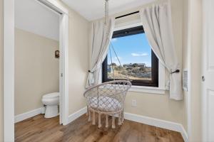 een rieten stoel in een badkamer met een raam bij Mountain View • Fire Pit + Hammock • Loft & Office in Humboldt +67 foto's