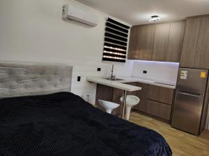 a small room with a bed and a kitchen at Lodge De Paradies in Quilpué