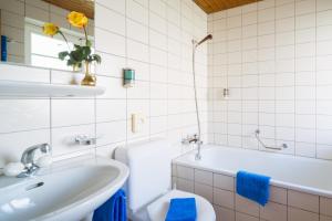 a bathroom with a tub and a sink and a toilet at Hotel Alpina in Mürren +35 photos