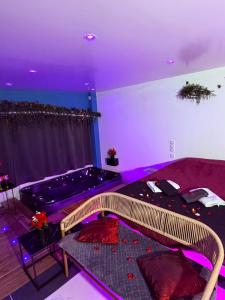 a living room with a tub in a room with purple lighting at Love 2 avec Jacuzzi in Cap d'Agde +32 photos