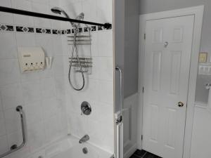 a white bathroom with a shower and a bath tub at Waterfront apartment in Gatineau +5 photos