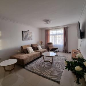 een woonkamer met een bank en een tafel bij Nadreya Nakuru Milimani Suite in Nakuru