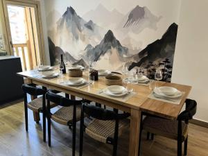 a dining room table with chairs and a mountain mural at Chalet N°5 - CHALET PRESTIGE 9 P. PROCHE PISTES-Tout inclus MAE-4253 in Vars