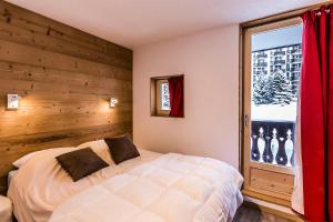 a bedroom with a bed and a window at Résidence Les Andes - 2 pièces charme refait a neuf MAE-1693 in Val dʼIsère