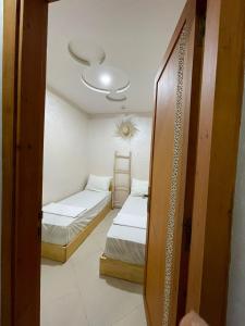 una piccola camera con due letti e una porta di AfricaCup's hostel a Tamraght Ouzdar