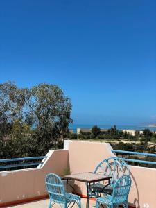 un patio con due sedie e un tavolo su un balcone di AfricaCup's hostel a Tamraght Ouzdar