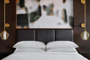 una camera da letto con un letto con due cuscini e un quadro di Indianapolis Marriott East a Indianapolis Altre 30 foto