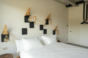 a bedroom with a white bed with lights on the wall at B&B Panevì in San Marcello
