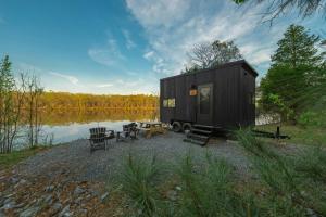 una piccola casa nera situata accanto a un lago di Postcard Cabins Talladega Valley, Outdoor Collection by Marriott Bonvoy a Childersburg