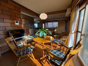 a dining room with a table and chairs at 三ツ和のお宿 in Nakano