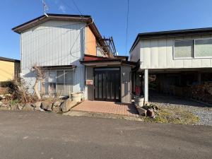 ein Haus mit einer großen Tür an der Seite in der Unterkunft 三ツ和のお宿 in Nakano