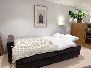a bed in a bedroom with a picture on the wall at Soft Stay Apartment in Bergen