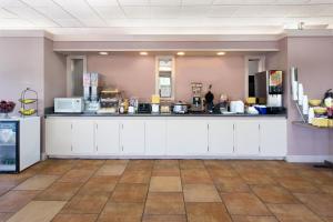 a kitchen with white cabinets and a counter at Days Inn by Wyndham Cullman in Cullman