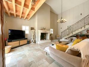 ein Wohnzimmer mit einem TV und einem Kamin in der Unterkunft Modern Provençal Villa At The Forest's Edge in Le Tignet
