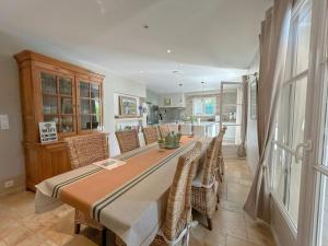 ein Esszimmer mit einem langen Tisch und Stühlen in der Unterkunft Modern Provençal Villa At The Forest's Edge in Le Tignet