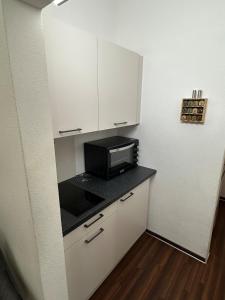 a kitchen with a microwave and a black counter top at Private Spa Suite bei Heilbronn - Romantik, Wellness & absolute Privatsphäre in Massenbachhausen +13 photos