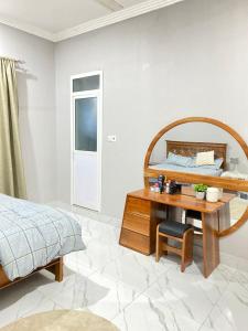 een slaapkamer met een bed en een houten tafel met een spiegel bij HalmaHome Two Bedroom Apartment in Zanzibar City