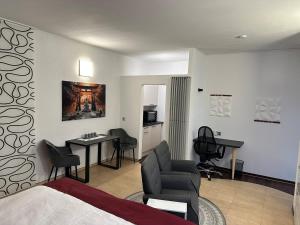 a hotel room with a bed and a desk and chairs at Private Spa Suite bei Heilbronn - Romantik, Wellness & absolute Privatsphäre in Massenbachhausen