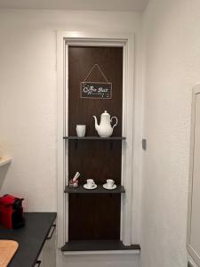 a shelf with a tea pot and cups on it at Private Spa Suite bei Heilbronn - Romantik, Wellness & absolute Privatsphäre in Massenbachhausen