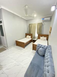 een woonkamer met twee bedden en een bank bij HalmaHome Two Bedroom Apartment in Zanzibar City +10 foto's
