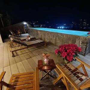 un balcone con tavolo, sedie e piscina di Cielo Nómada a Valle de Bravo
