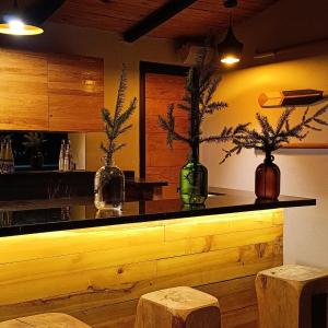 un bar con tre vasi su un bancone con due sgabelli di Cielo Nómada a Valle de Bravo