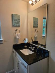 ein Badezimmer mit Waschbecken und Spiegel in der Unterkunft Downtown Access • Fenced Yard • Sleeps 10 in McKinney + 22 Fotos