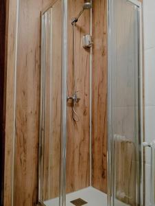 una ducha con mampara de cristal en un baño en Hostal La Sierra Cabárceno, en Sarón