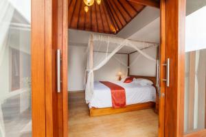 a bedroom with a bed and a glass door at Villa Pantina Bali in Uluwatu