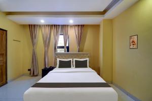 a bedroom with a large white bed in front of a window at Hotel O Silver Orchid in Muragācha