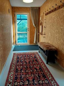 Una sala de estar con una alfombra y una ventana. en Retro Guest House Near Rebild Hills, en Hadsund