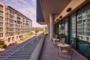 ein Balkon mit Tischen und Stühlen auf einem Gebäude in der Unterkunft The REMI, Scottsdale, Autograph Collection in Scottsdale