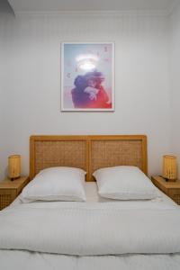 ein Bett mit zwei Kissen und einem Bild an der Wand in der Unterkunft Charming 2P ideally located - Garibaldi & Port in La Celle-sous-Gouzon