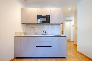 eine Küche mit Spüle und Mikrowelle in der Unterkunft Charming 2P ideally located - Garibaldi & Port in La Celle-sous-Gouzon