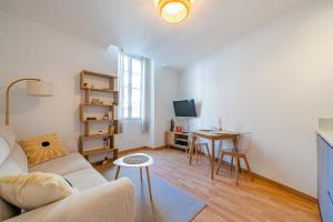 ein Wohnzimmer mit Sofa und Tisch in der Unterkunft Charming 2P ideally located - Garibaldi & Port in La Celle-sous-Gouzon