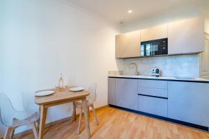 eine Küche mit einem Holztisch und einem kleinen Tisch mit Stühlen in der Unterkunft Charming 2P ideally located - Garibaldi & Port in La Celle-sous-Gouzon + 7 Fotos