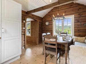 una sala da pranzo con un tavolo e un divano di Timber Cabin With Soul At Kvamskogen a Norheimsund