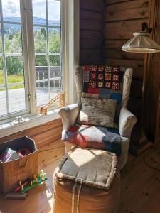 un soggiorno con una sedia e una finestra di Timber Cabin With Soul At Kvamskogen a Norheimsund Altre 10 foto