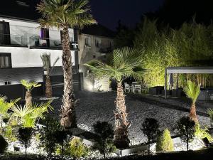 a courtyard with palm trees and a building at night at Appartement T3 in Frontenex-Villard-Rosset