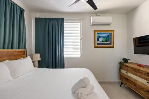 a bedroom with a white bed and a television at Ocean Park 3BDR 2b Hot tub-Terrace Riviera Villa in San Juan +12 photos