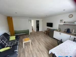 a living room with a couch and a table at Guests House in La Vespière