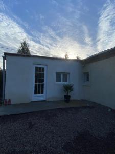 a white house with a potted plant in front of it at Guests House in La Vespière