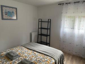 a small bedroom with a bed and a window at Guests House in La Vespière